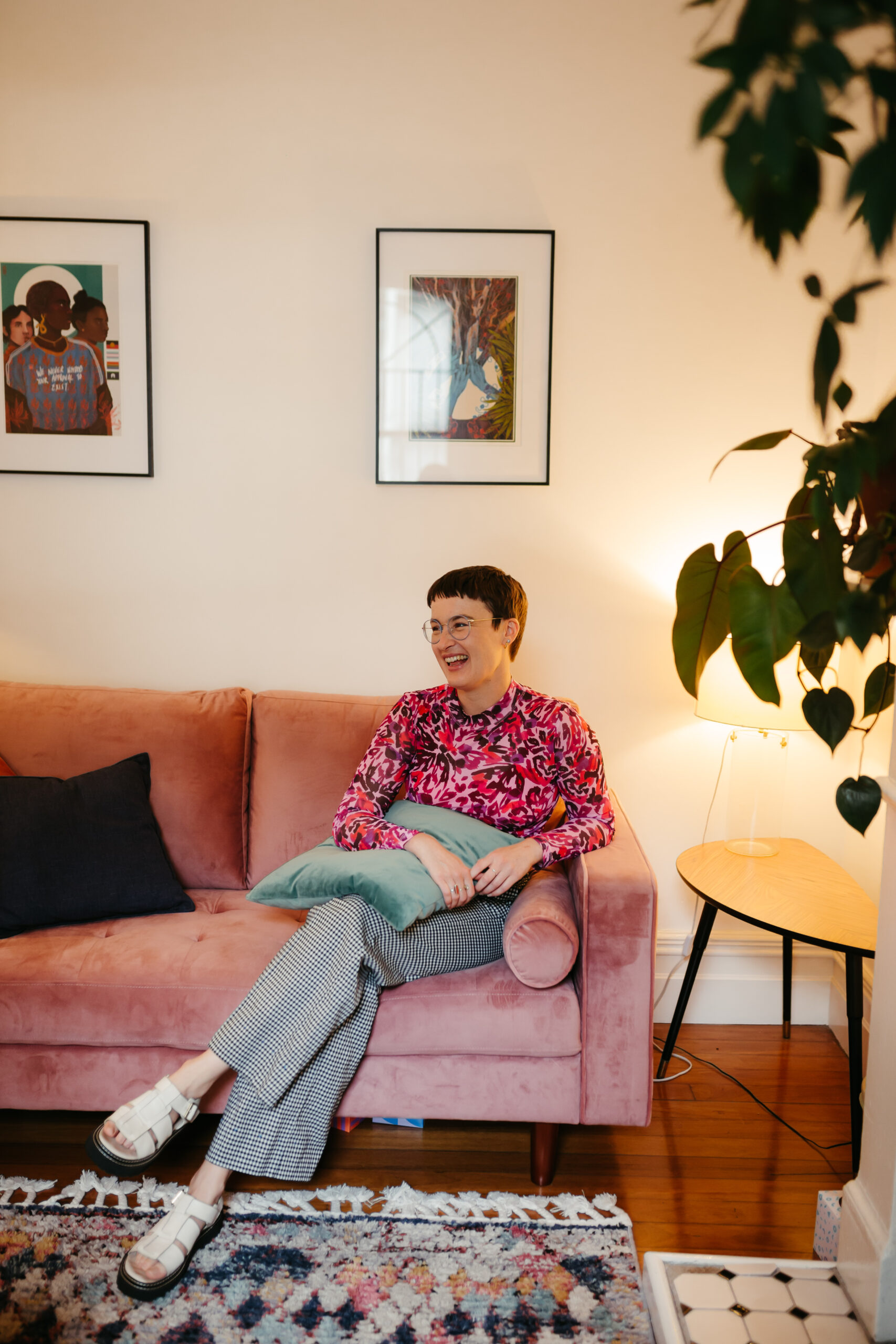 Chauncey Sjostedt, Gestalt Therapist and Psychotherapist, relaxed in her home with LGBTQ+ artwork visible