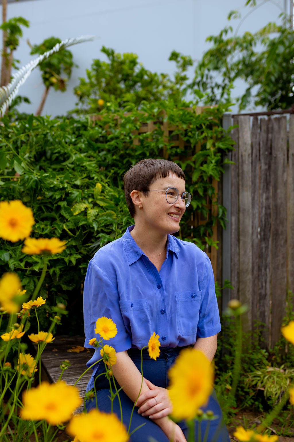 Chauncey Sjostedt in a garden surrounded by yellow flowers, reflecting her warmth and authenticity